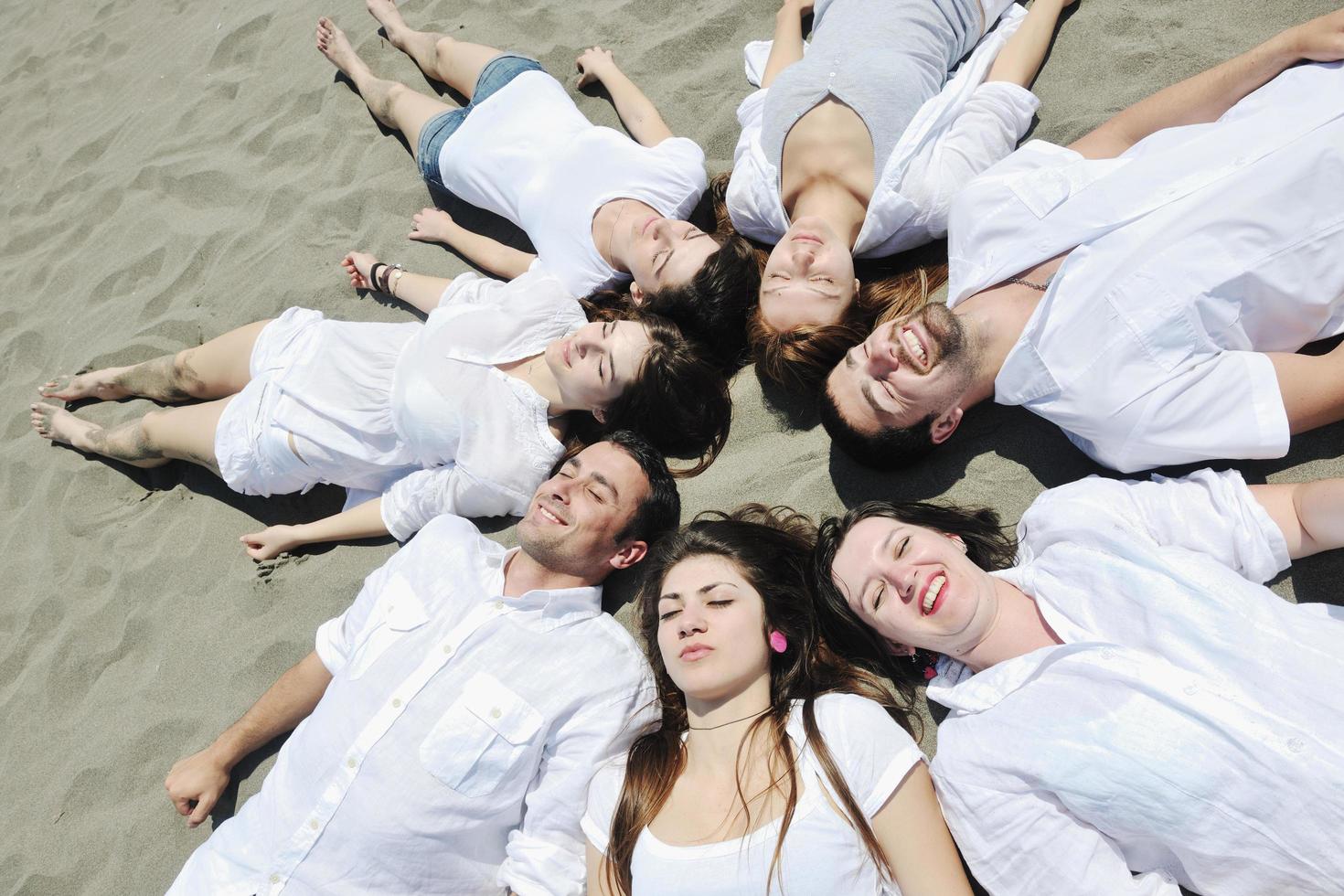 grupo de jovens felizes em se divertir na praia foto