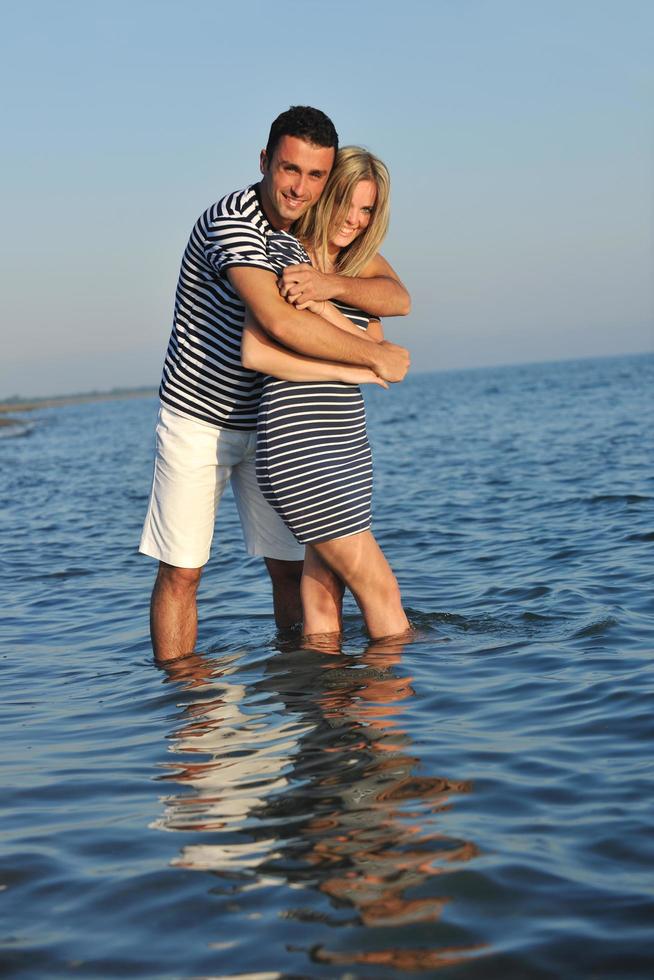 feliz casal jovem tem tempo romântico na praia foto