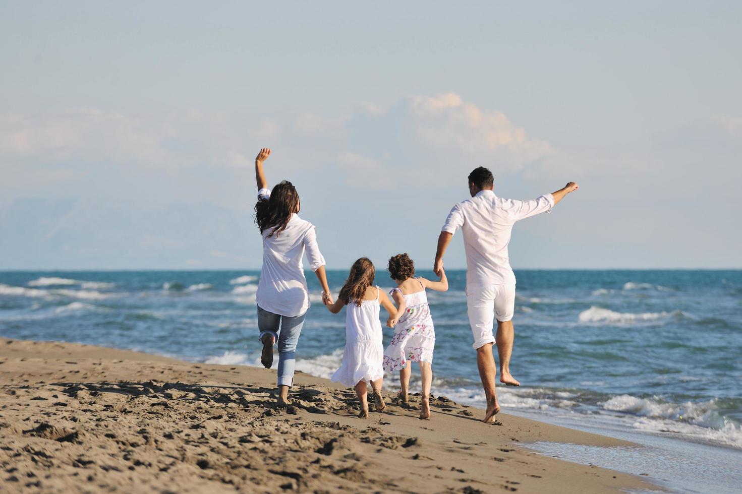 feliz jovem família se divertir na praia foto