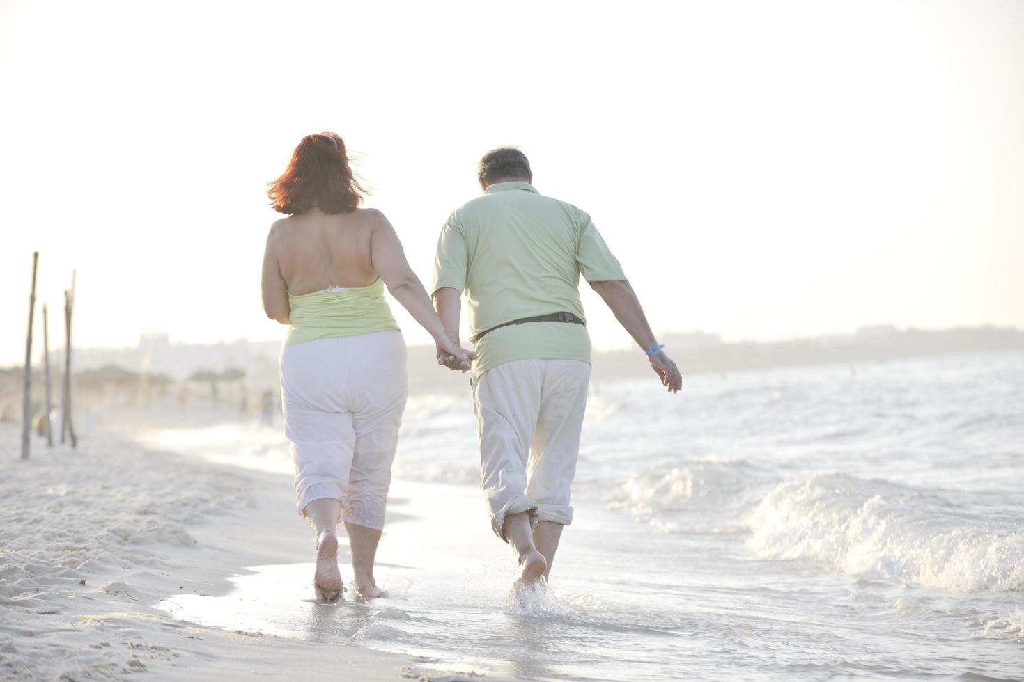 casal de idosos feliz na praia foto