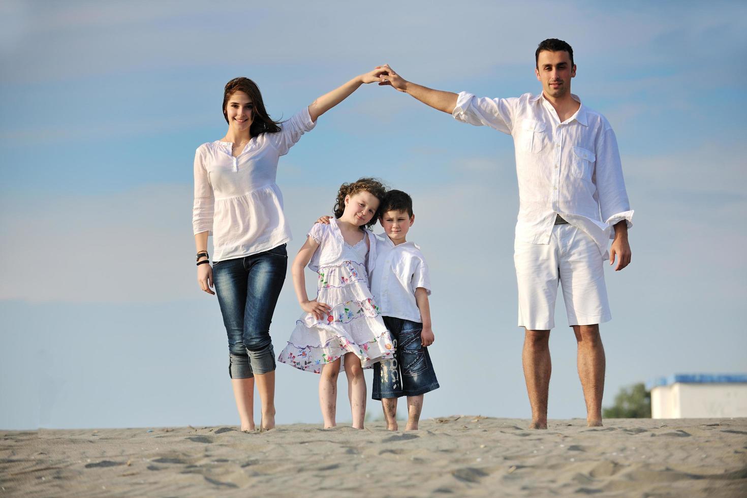 família na praia mostrando sinal de casa foto