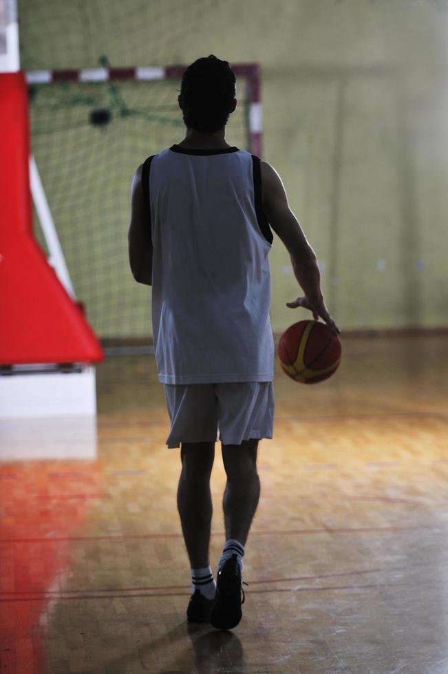 jogador de jogo de bola de basquete no pavilhão desportivo foto