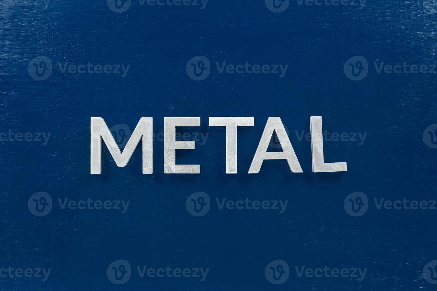 a palavra metal colocada com letras prateadas na superfície de cor azul foto