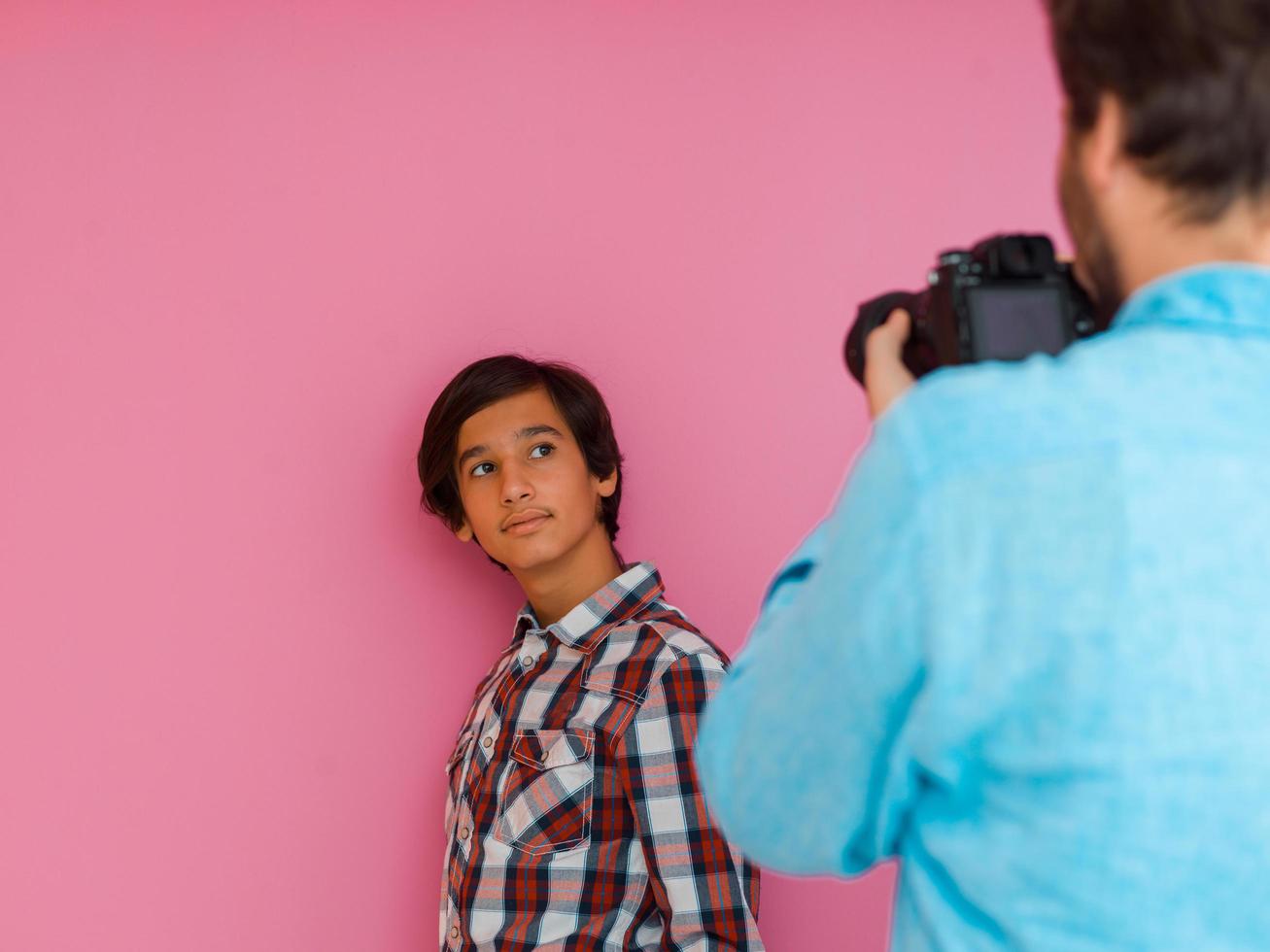 uma foto de pai e filho tirando fotos de família na casa em frente a uma parede roxa. foco seletivo