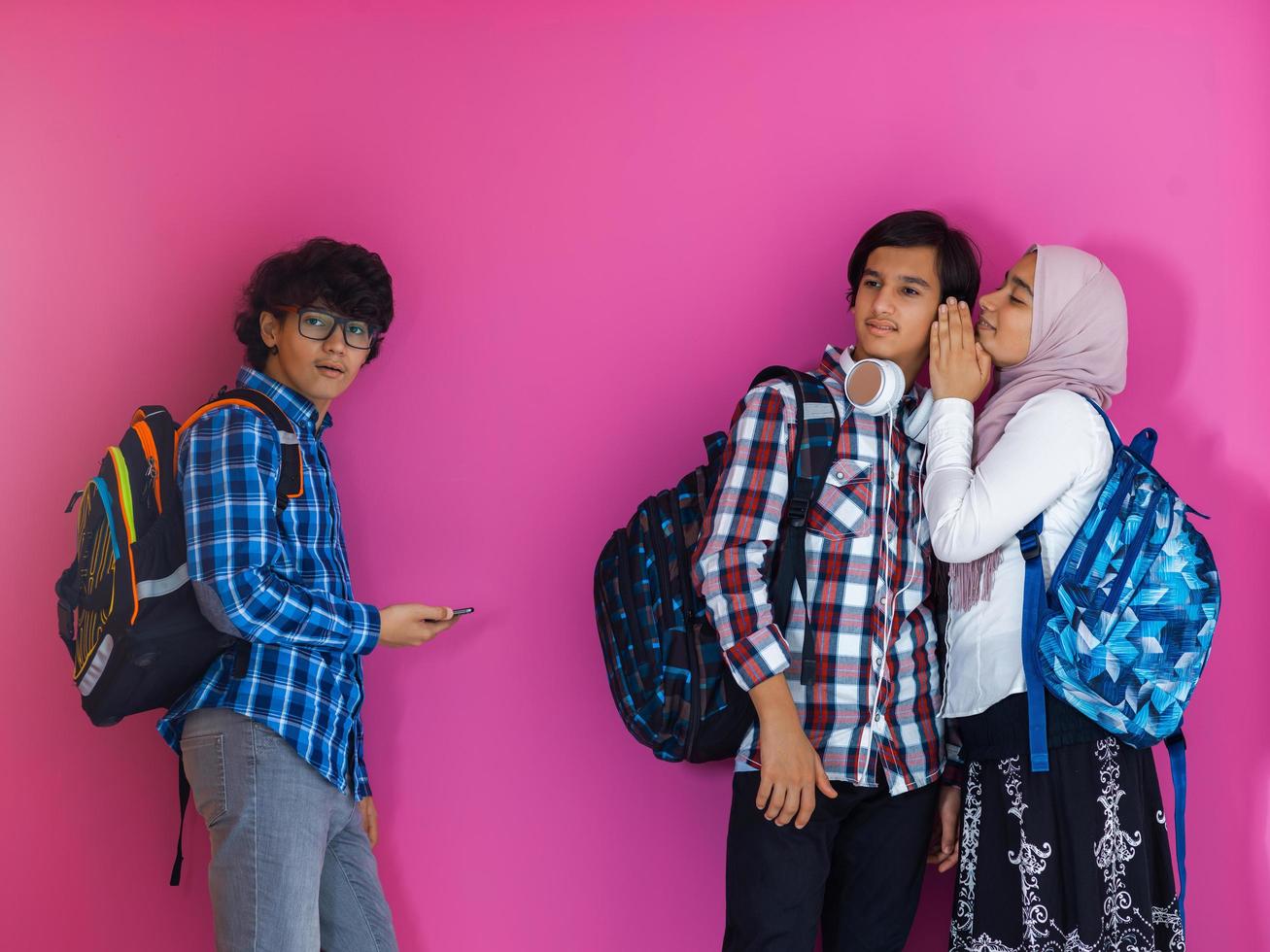 um grupo de adolescentes árabes, uma equipe de estudantes caminhando para o futuro e voltando para a escola o conceito de um fundo rosa. o conceito de educação bem sucedida para os jovens. foco seletivo foto