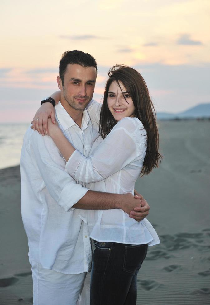 feliz casal jovem se divertir na praia foto