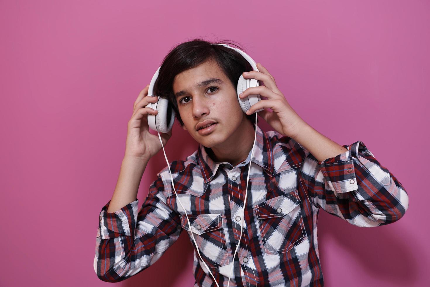 adolescente árabe usando fones de ouvido e ouvindo música foto