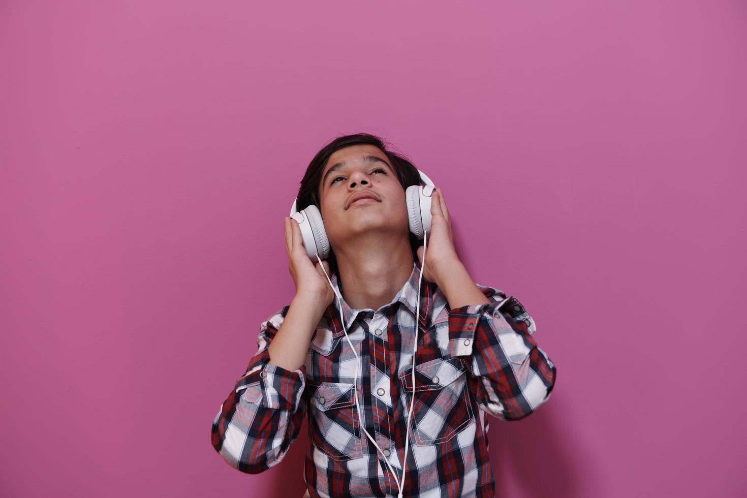 adolescente árabe usando fones de ouvido e ouvindo música foto