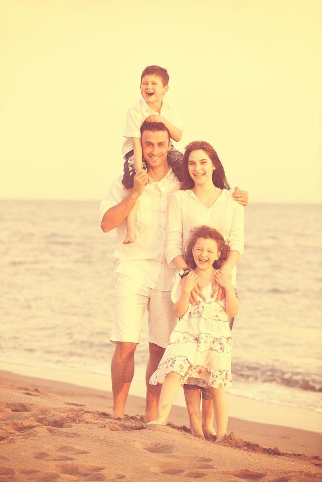 feliz jovem família se divertir na praia foto