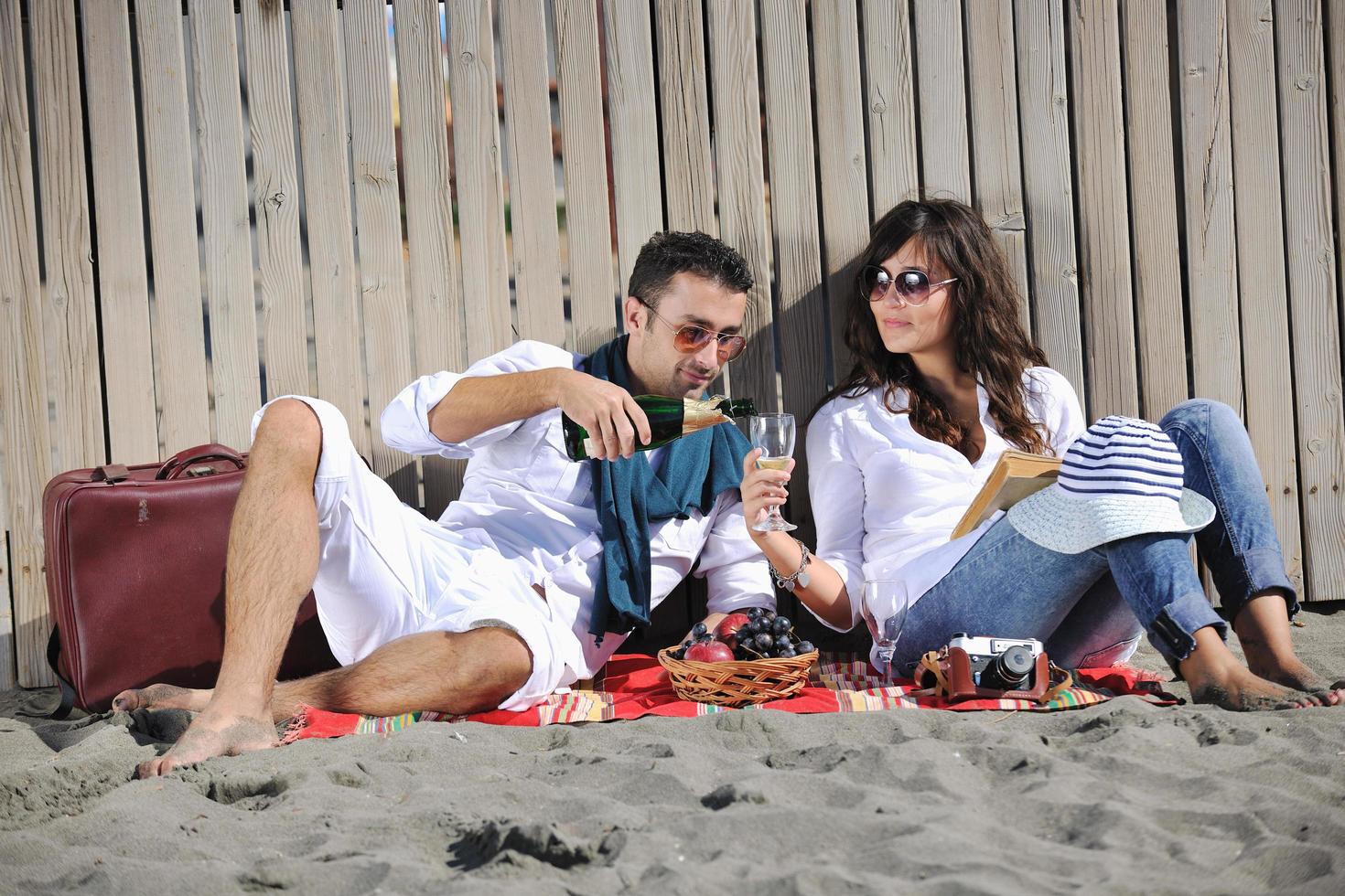 jovem casal desfrutando de piquenique na praia foto