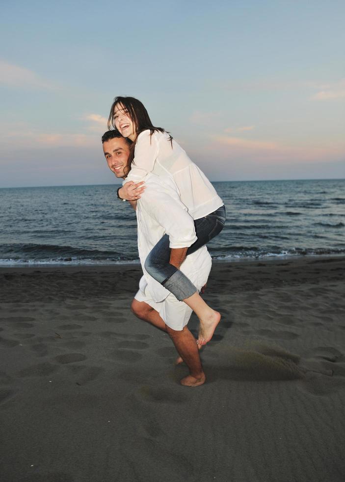 feliz casal jovem se divertir na praia foto