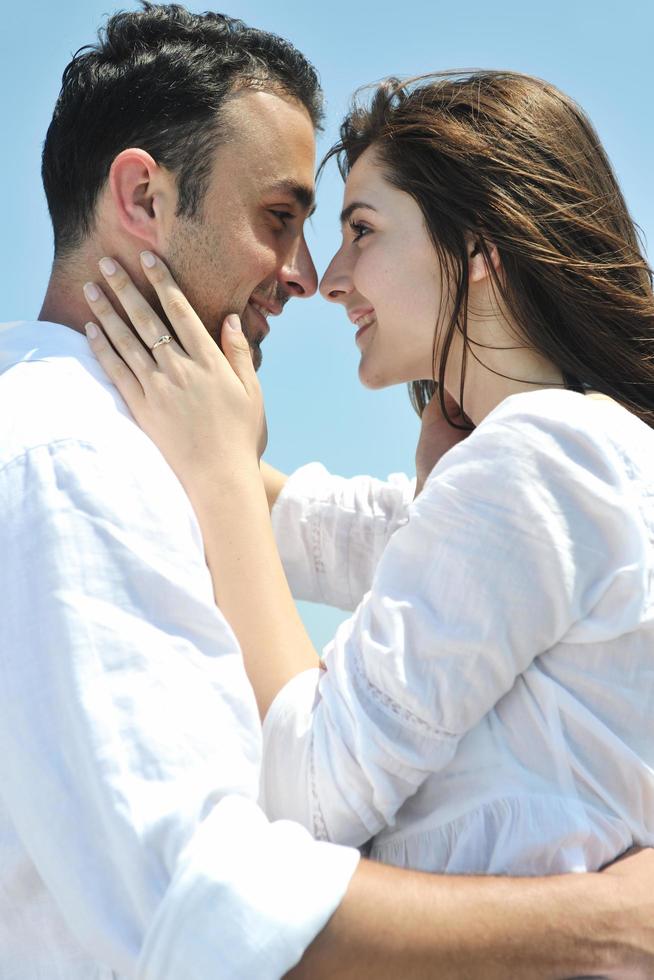 feliz casal jovem se divertir na praia foto