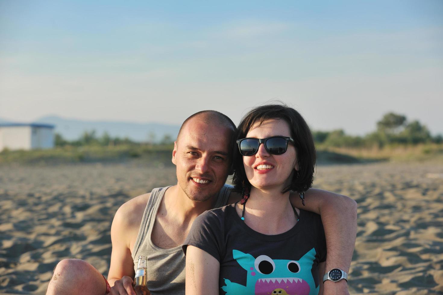 feliz casal jovem se divertir na praia foto