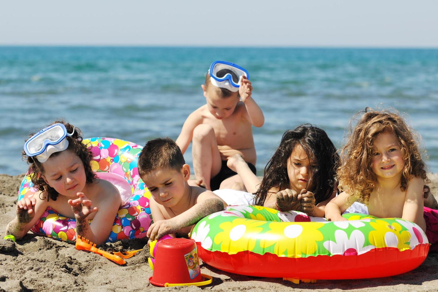 grupo infantil se diverte e brinca com brinquedos de praia foto