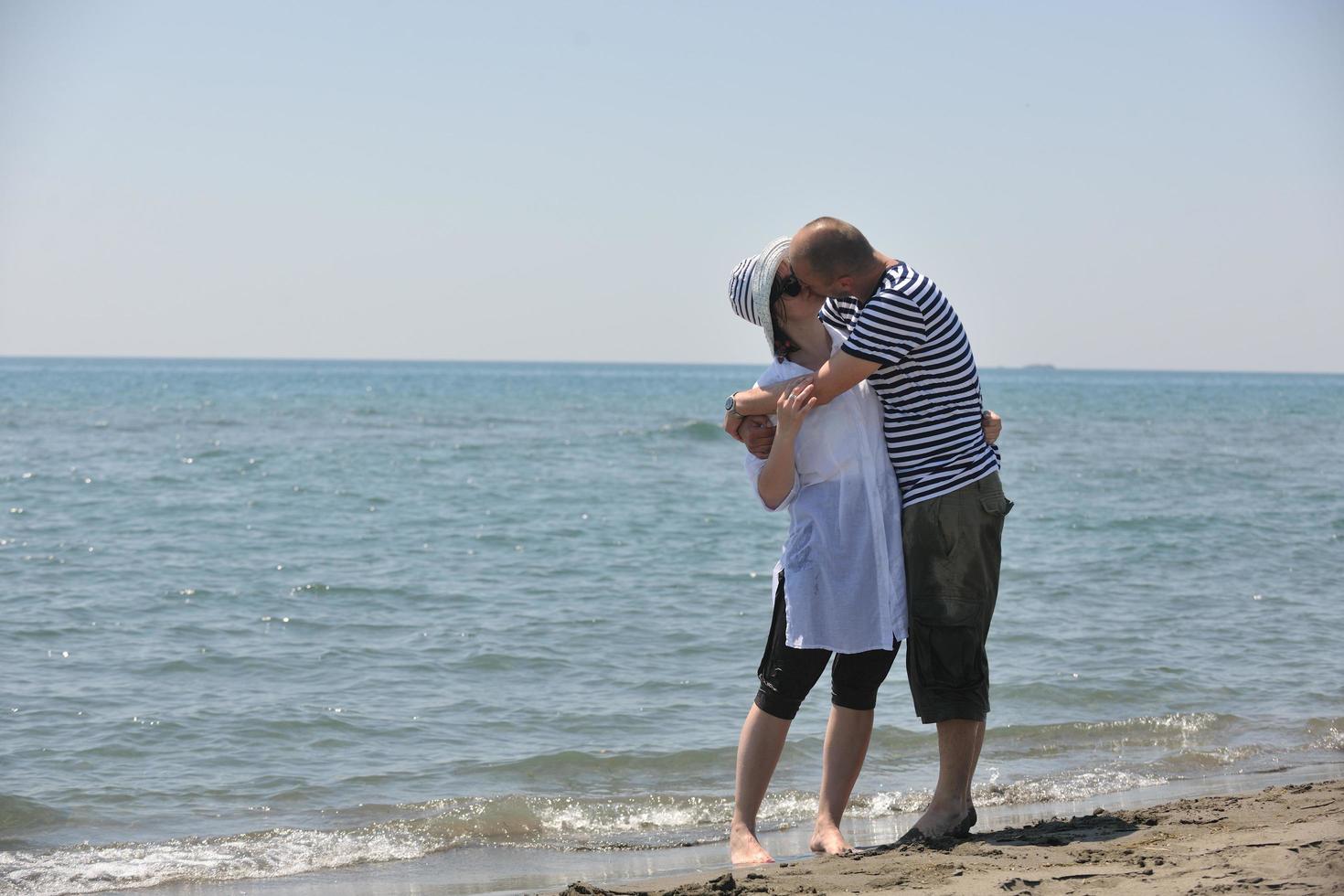 feliz casal jovem se divertir na praia foto