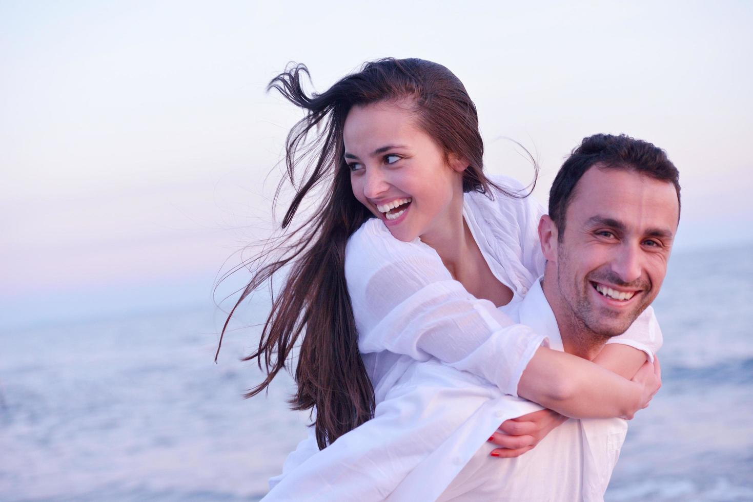 jovem casal na praia se divertir foto