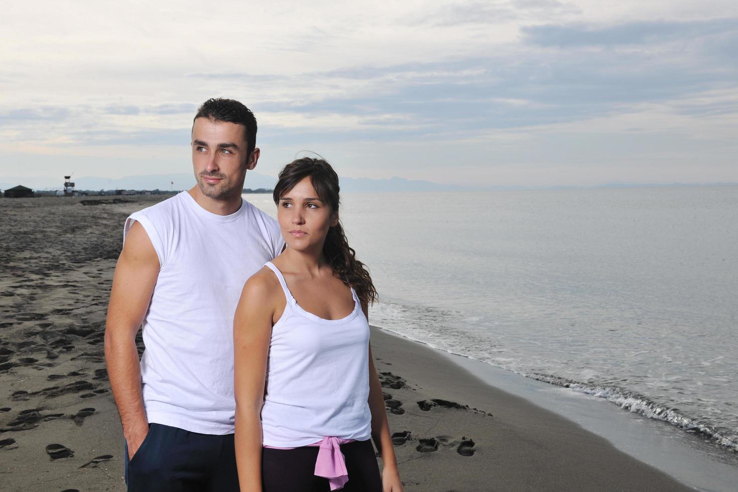 feliz casal jovem se diverte na bela praia foto