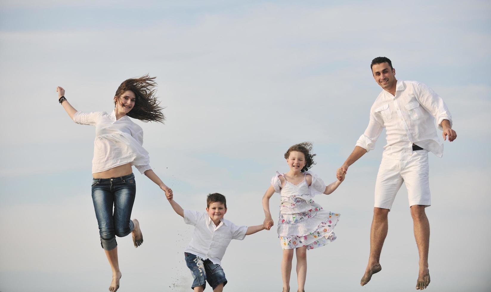 feliz jovem família se divertir na praia foto