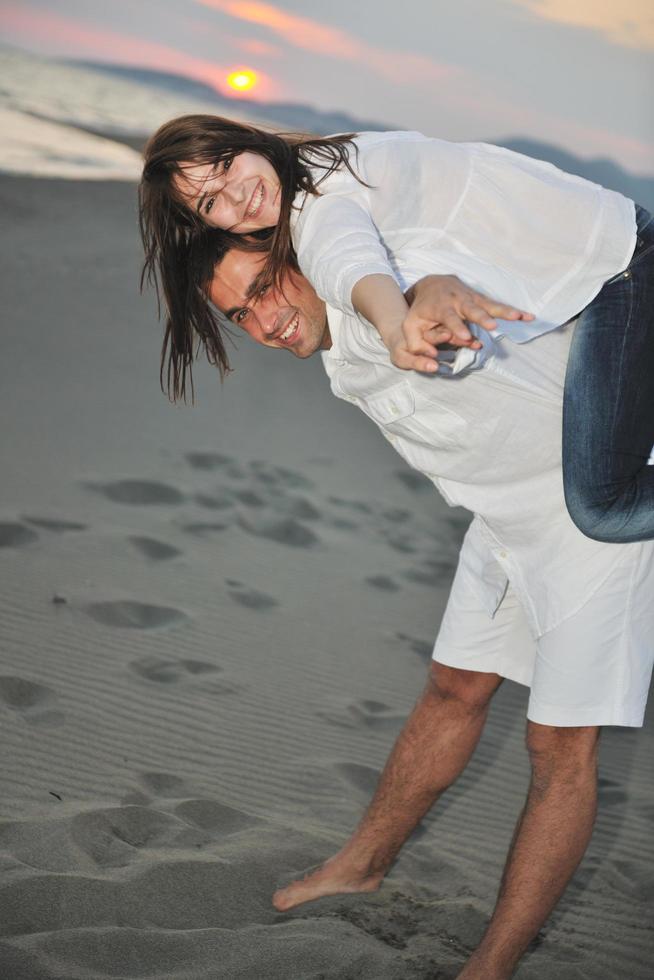 feliz casal jovem se divertir na praia foto