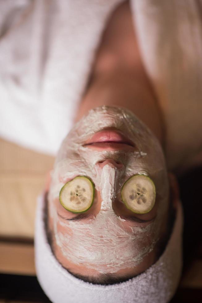 mulher está recebendo máscara facial de argila no spa foto