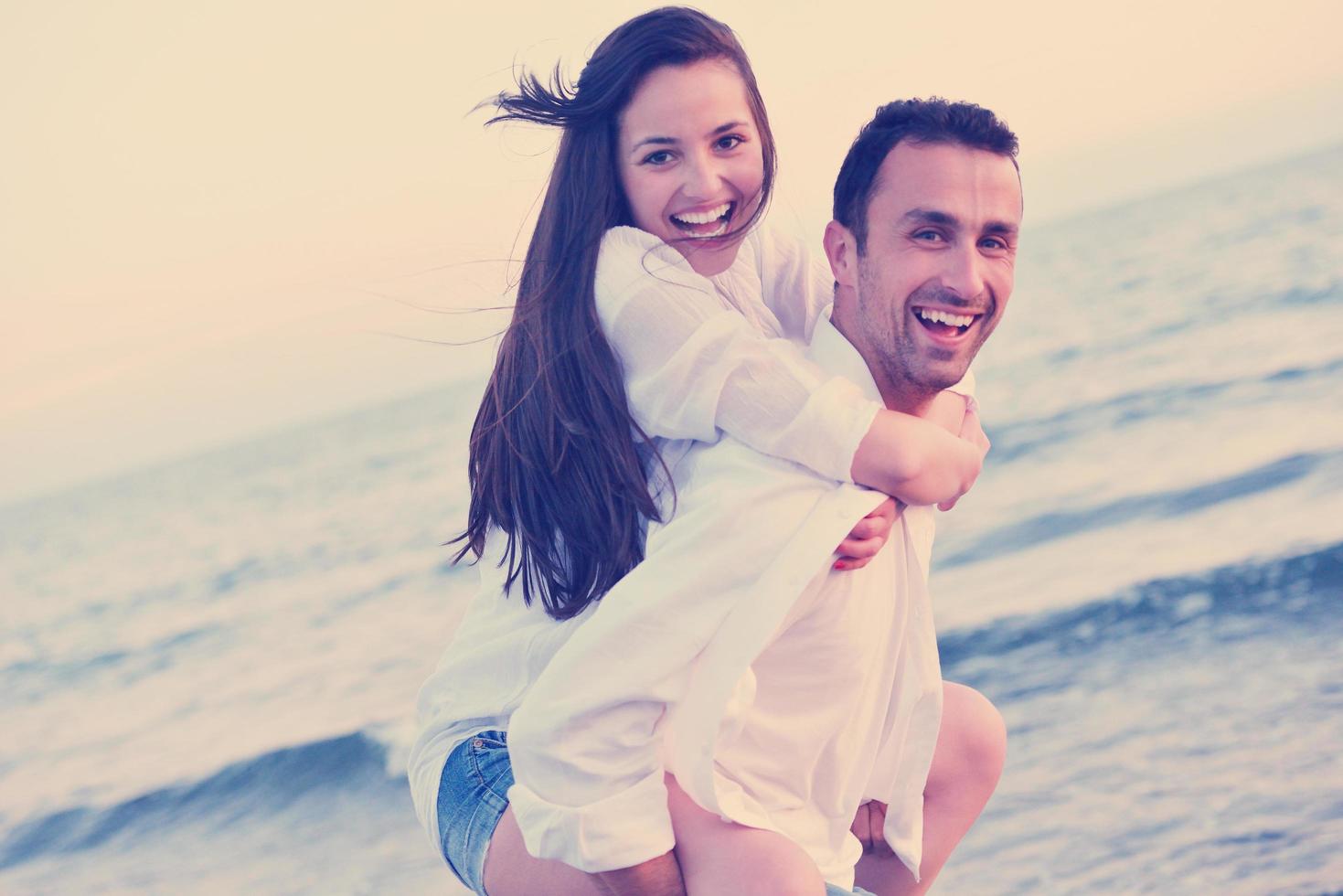 jovem casal na praia se divertir foto