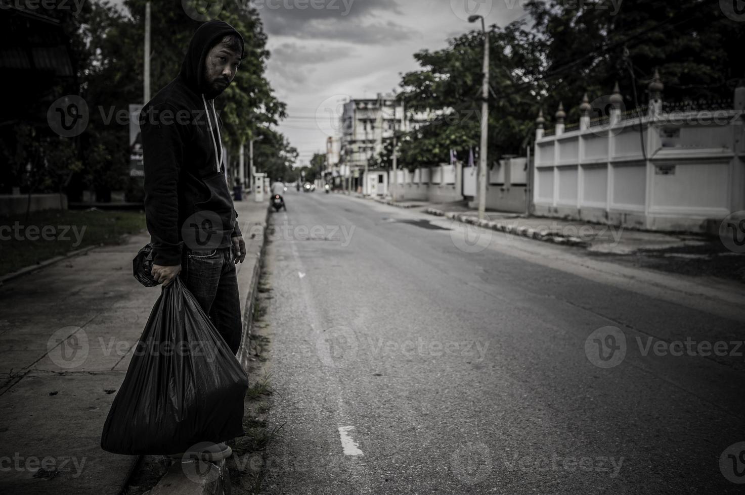 homem asiático é sem-teto na estrada lateral, um estranho tem que viver sozinho na estrada porque não tem família. foto