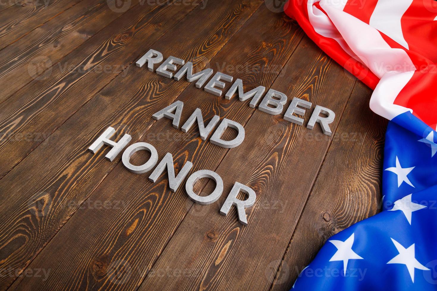 palavras lembram e honram colocadas com letras de metal prateado sobre fundo de madeira com bandeira dos eua no lado direito foto
