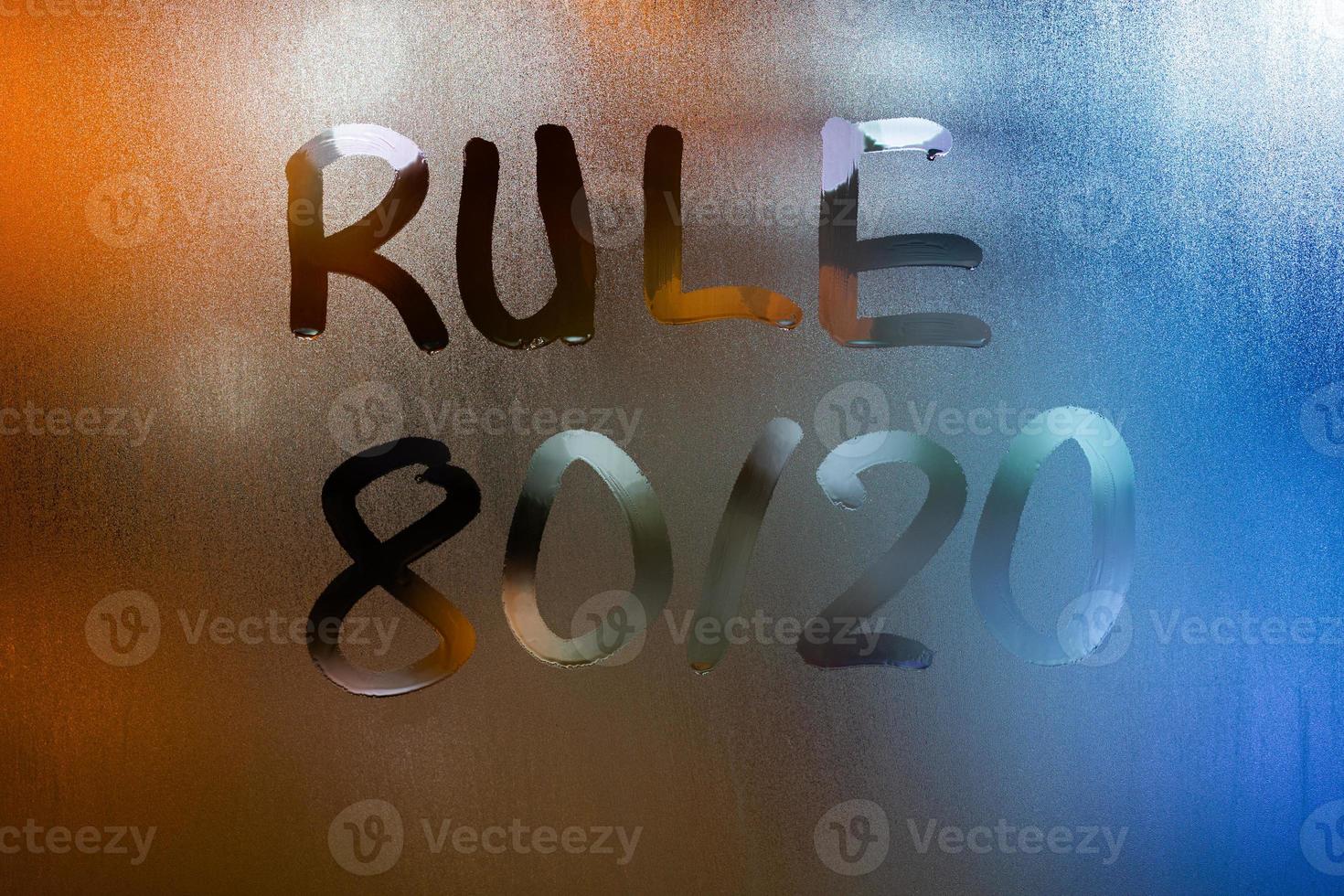 a frase regra 80 por 20 - escrita à mão no vidro da janela molhada da noite azul foto