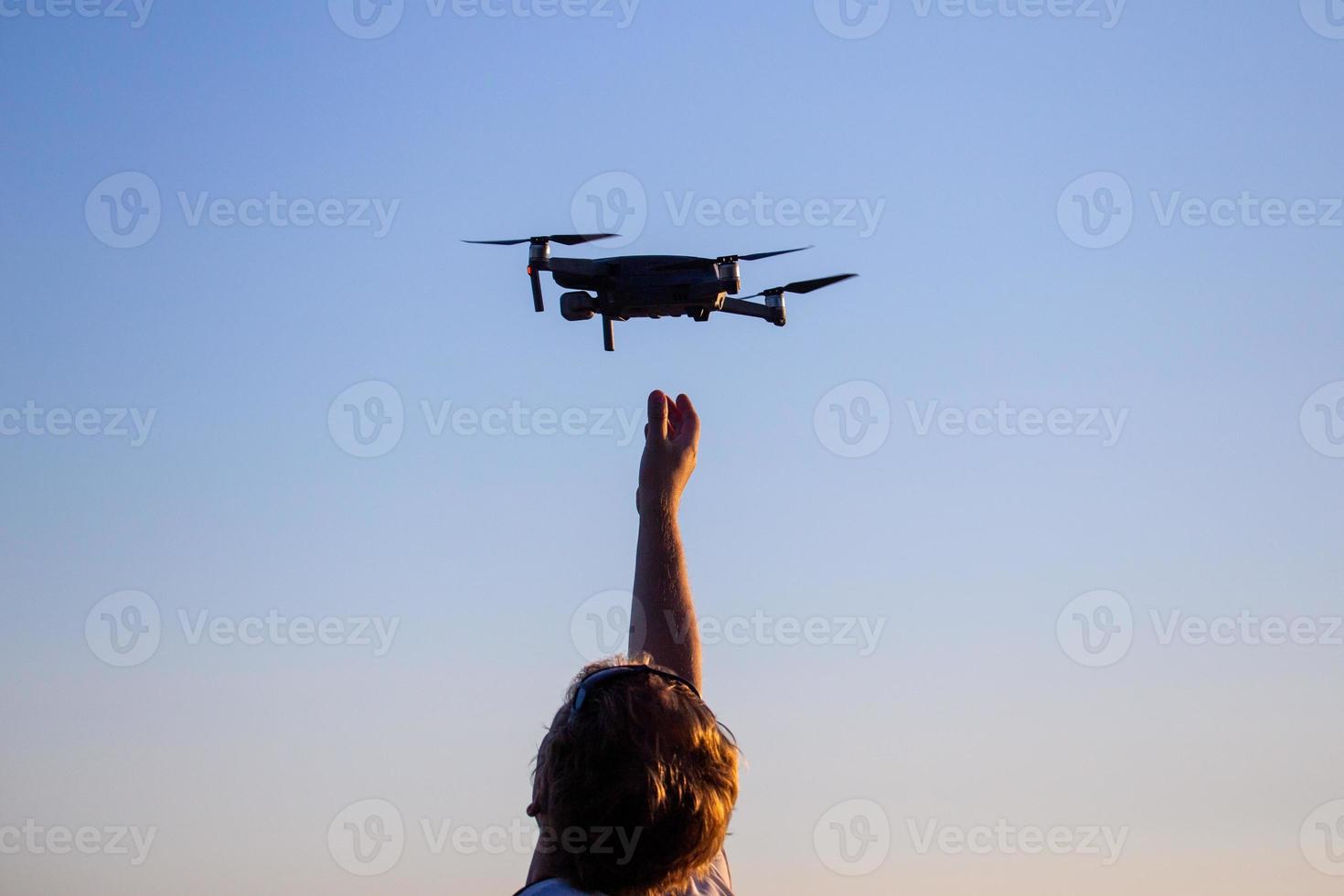 homem caucasiano loiro pegando pequeno drone quadcopter foto