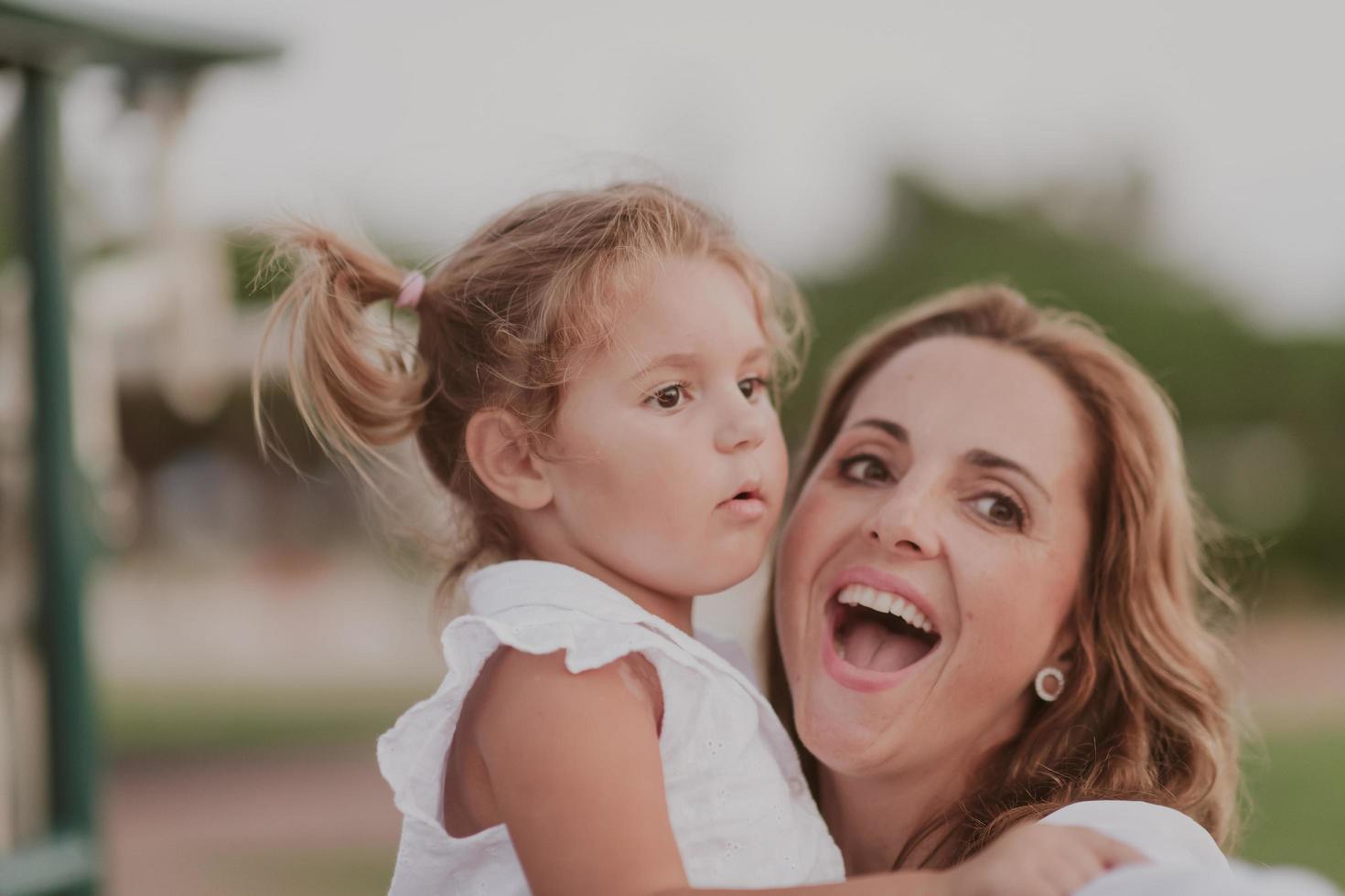 uma mulher idosa em roupas casuais com sua filha passa tempo juntos no parque de férias. tempo para a família. foco seletivo foto