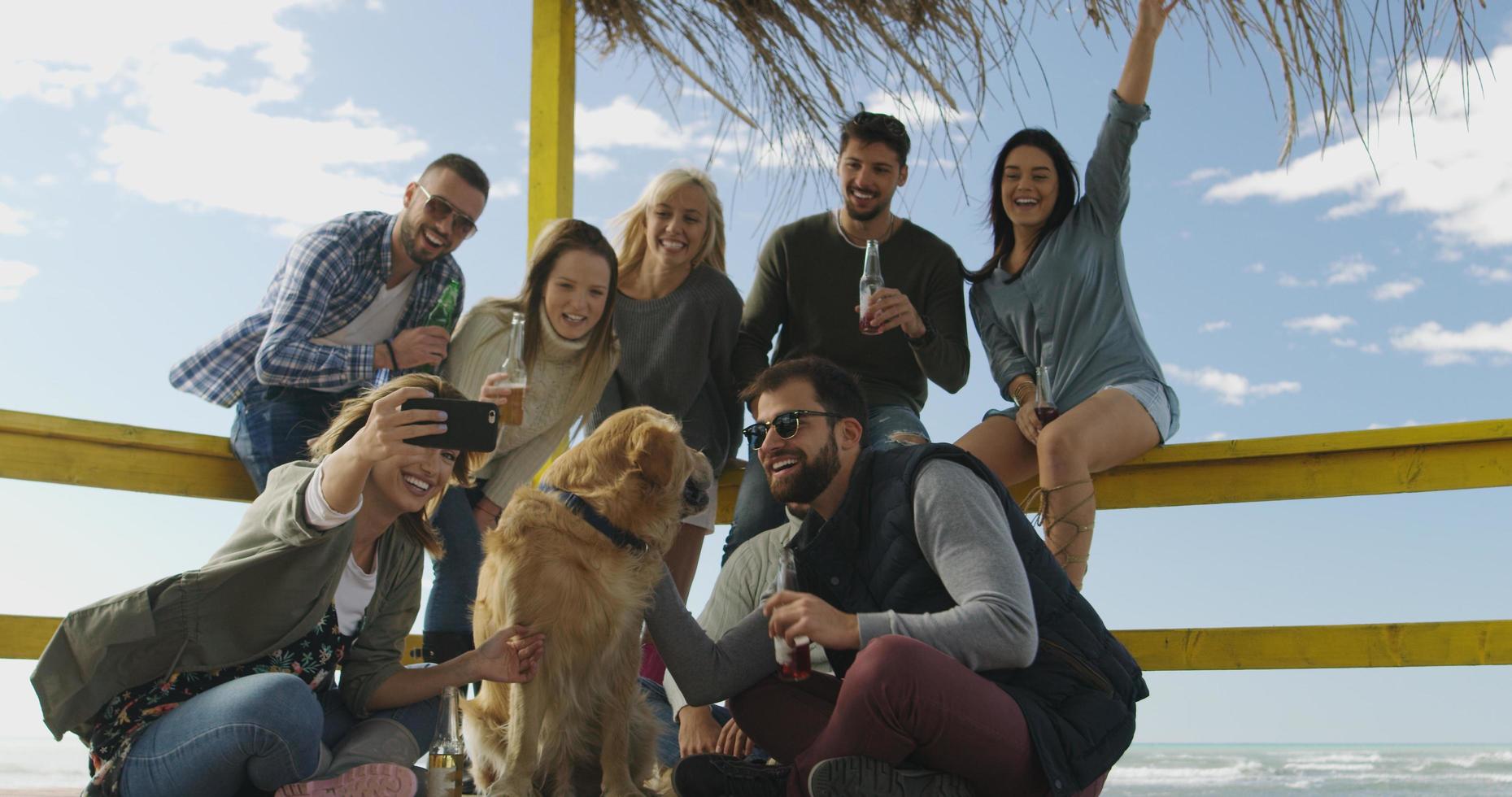 grupo de amigos se divertindo no dia de outono na praia foto