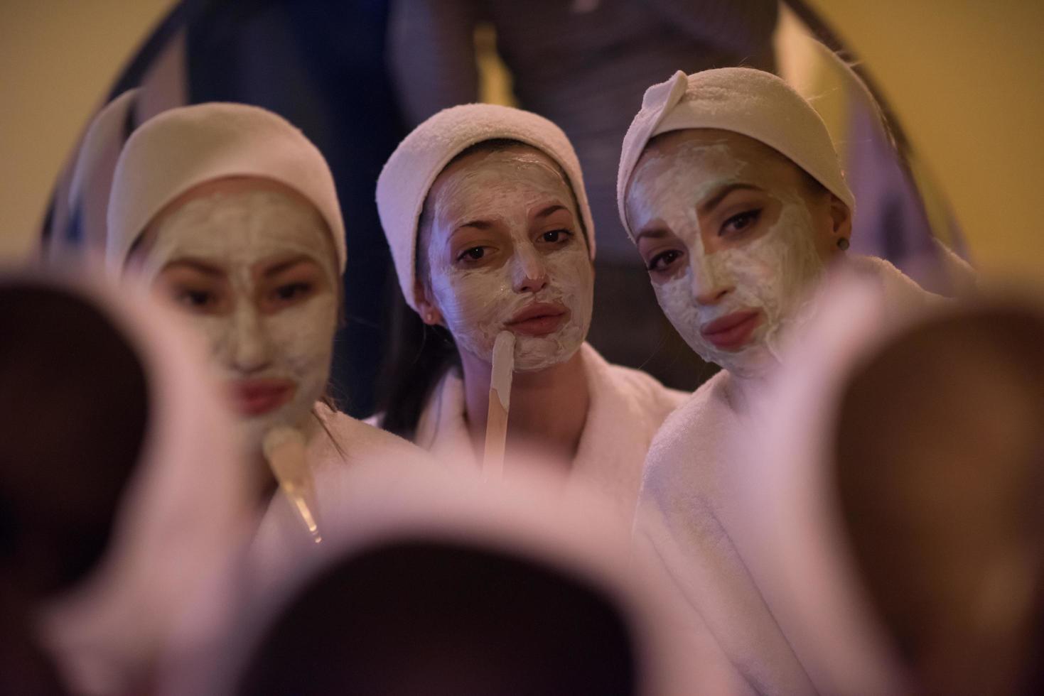 mulheres colocando máscaras no banheiro foto