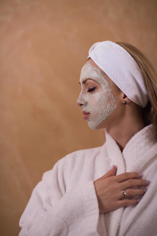 mulher de spa aplicando máscara facial foto