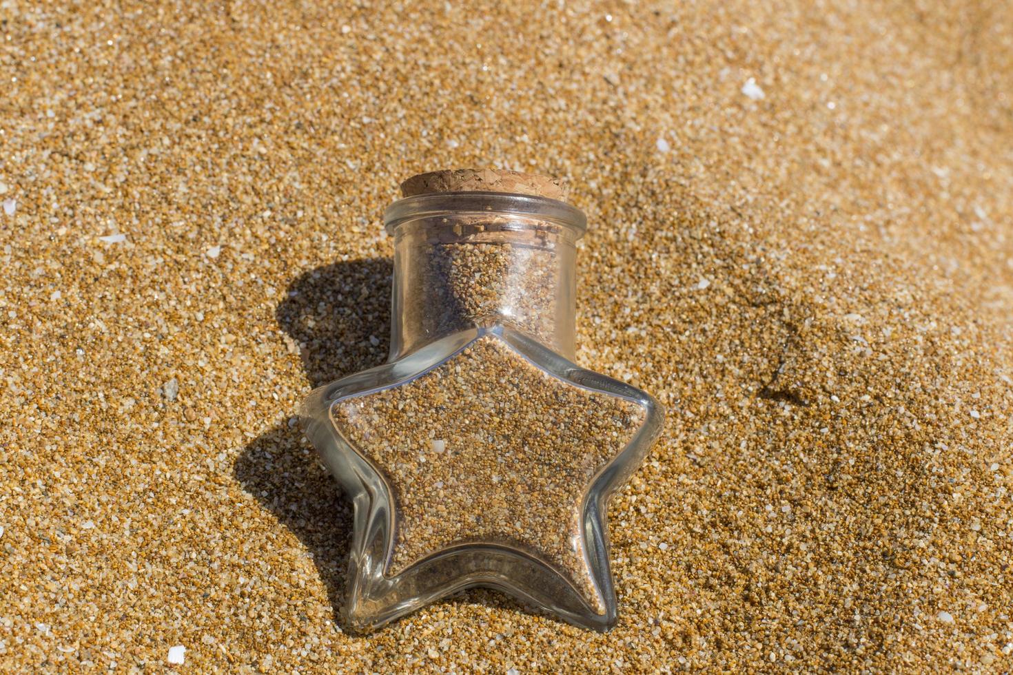 recipiente de vidro cheio de areia foto