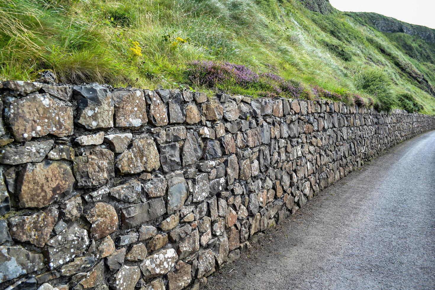 parede de pedra ao longo da estrada de cascalho foto