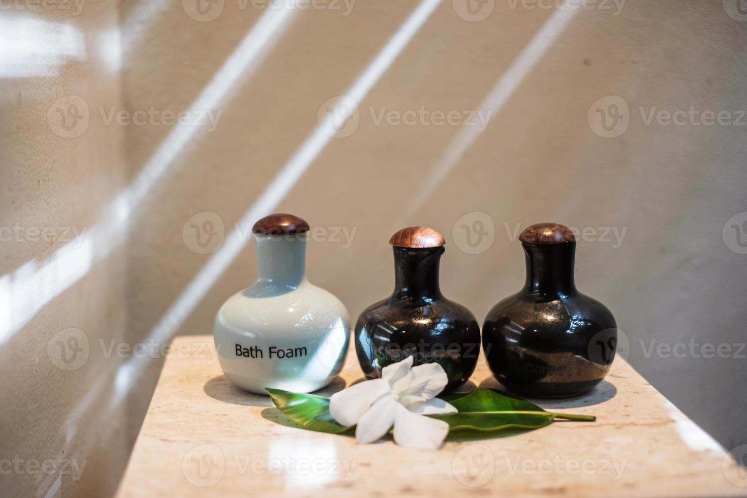 garrafas de produtos de higiene pessoal no banheiro do hotel de luxo ou casa moderna. conjunto de recipientes de banho, gel de banho corporal, xampu e condicionador de cabelo em cerâmica foto