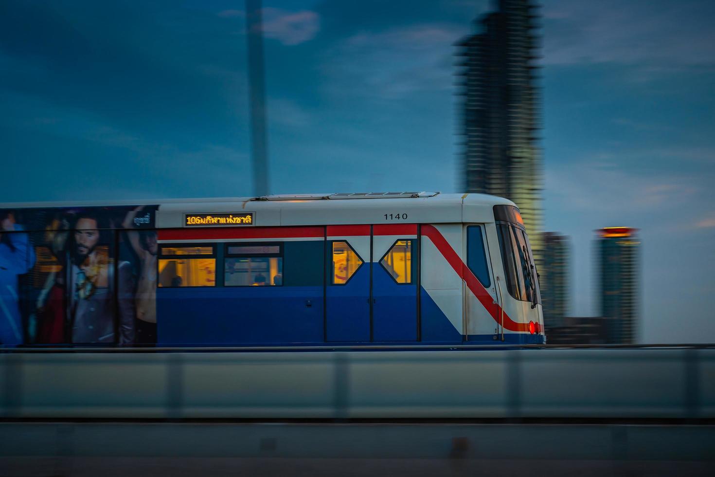 bangkok, tailândia maio 29 bts sky train passando pela ponte taksin saphan taksin ou saphan sathorn à noite em 29 de maio de 2022 em bangkok, tailândia. foto