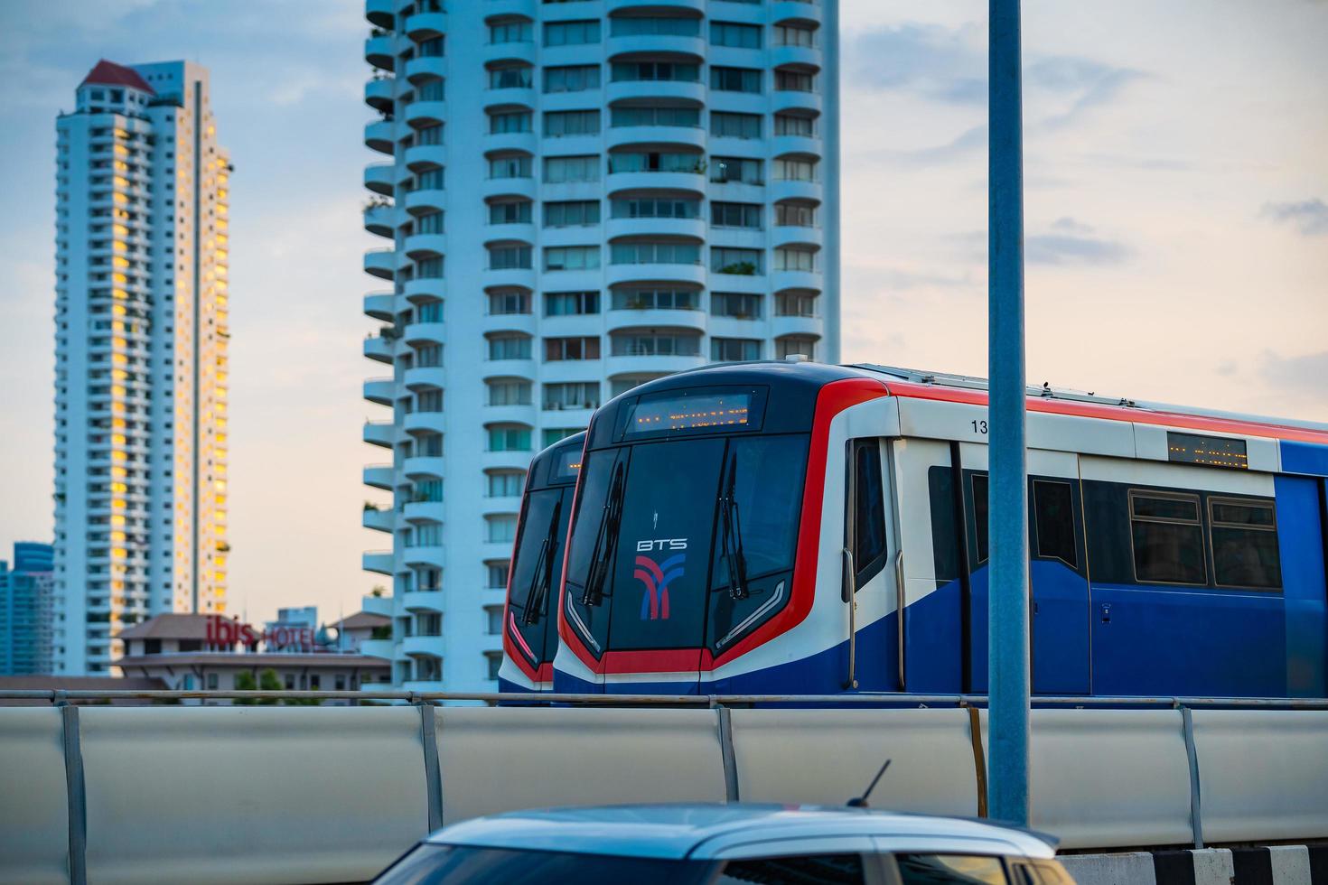 bangkok, tailândia maio 29 bts sky train passando pela ponte taksin saphan taksin ou saphan sathorn à noite em 29 de maio de 2022 em bangkok, tailândia. foto