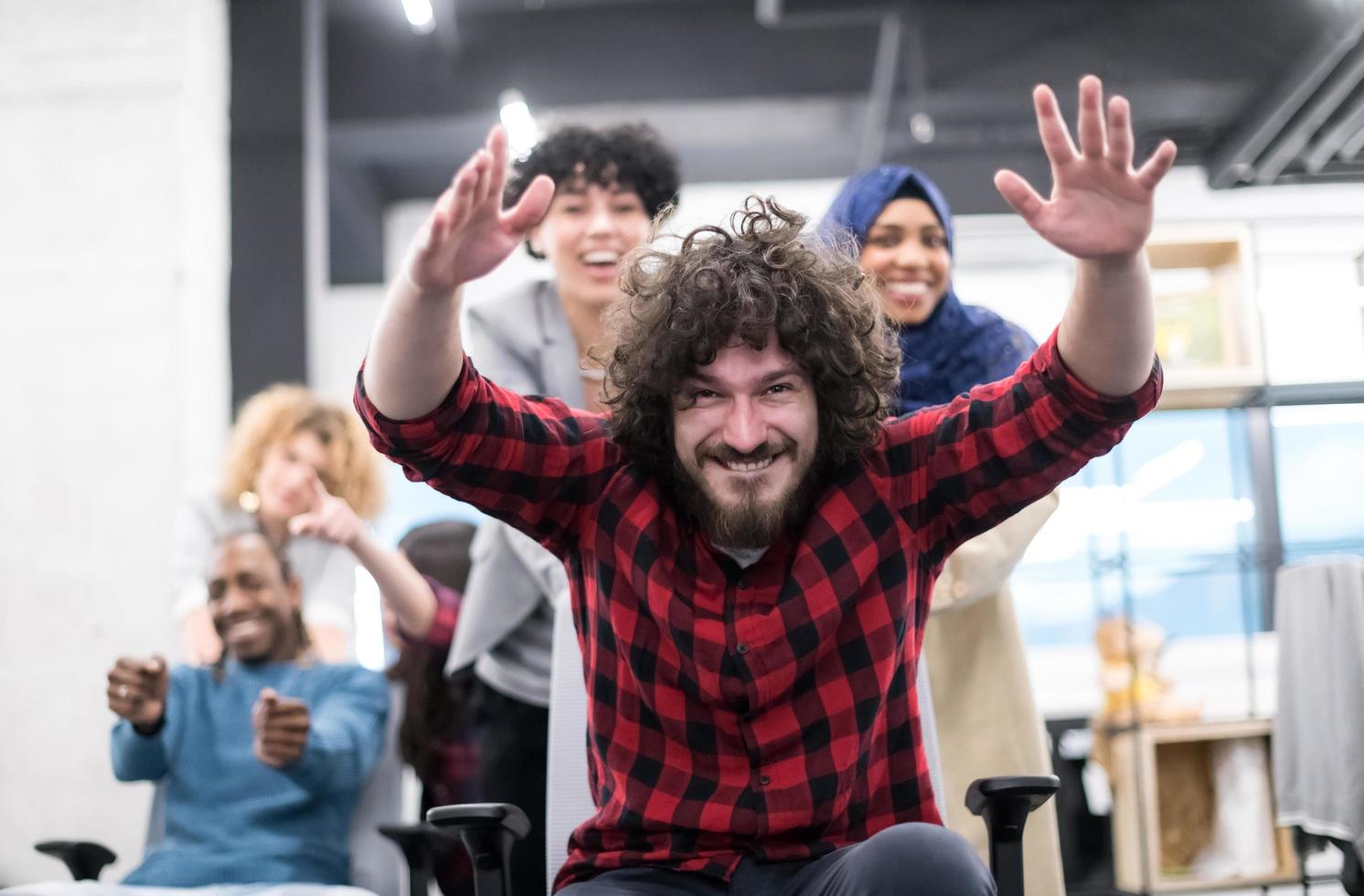 equipe de negócios multiétnica competindo em cadeiras de escritório foto