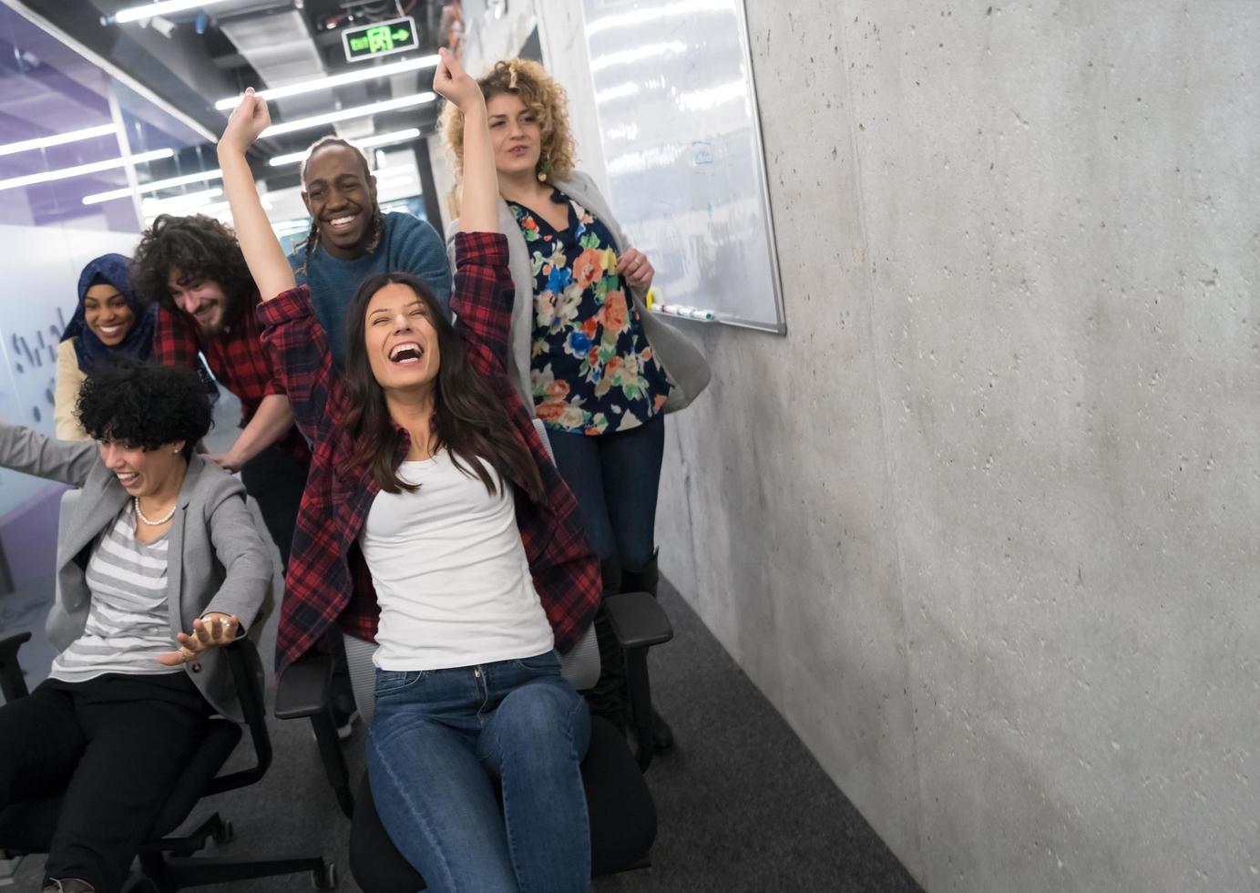 equipe de negócios multiétnica competindo em cadeiras de escritório foto