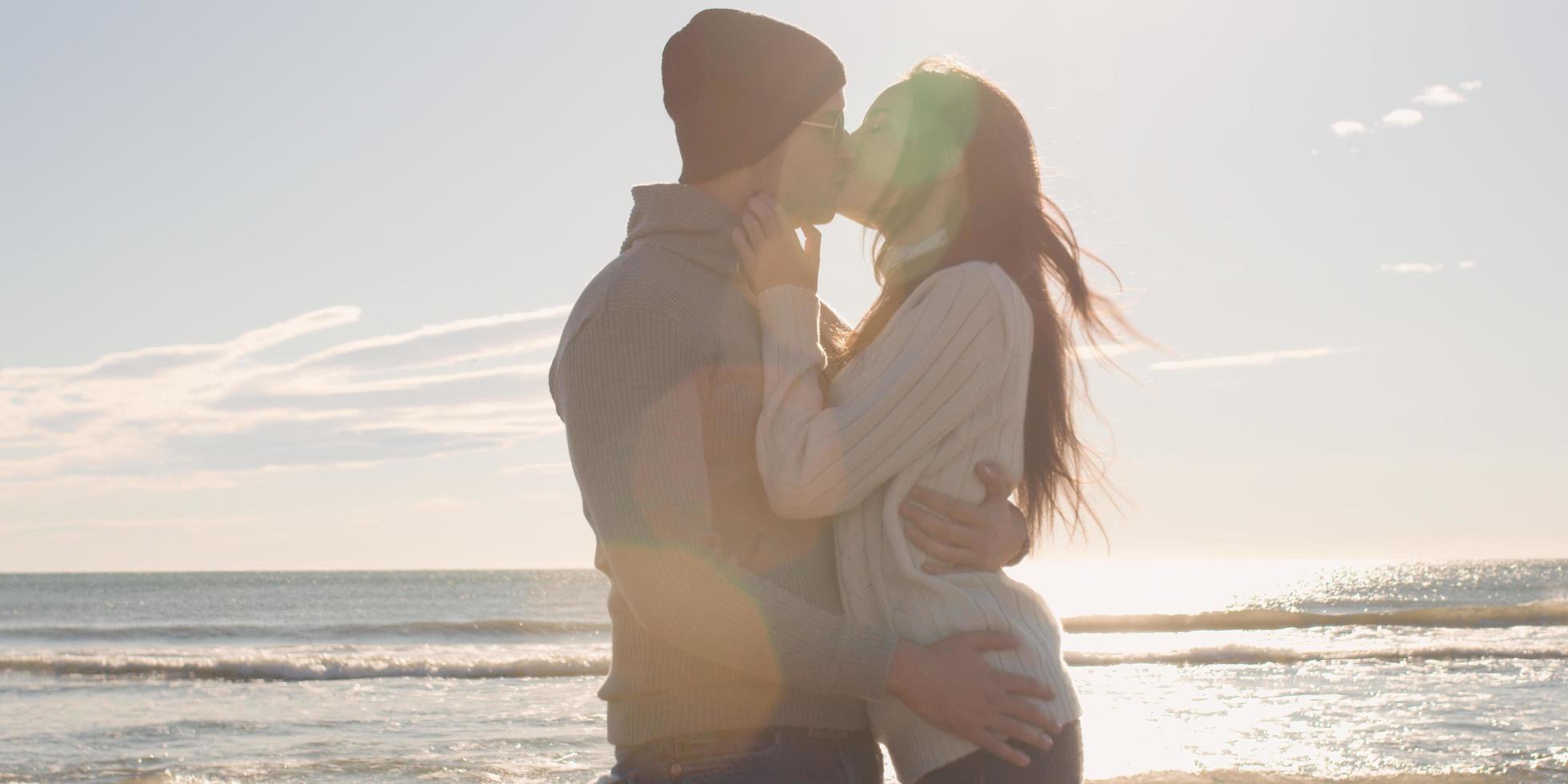 casal se divertindo em lindo dia de outono na praia foto