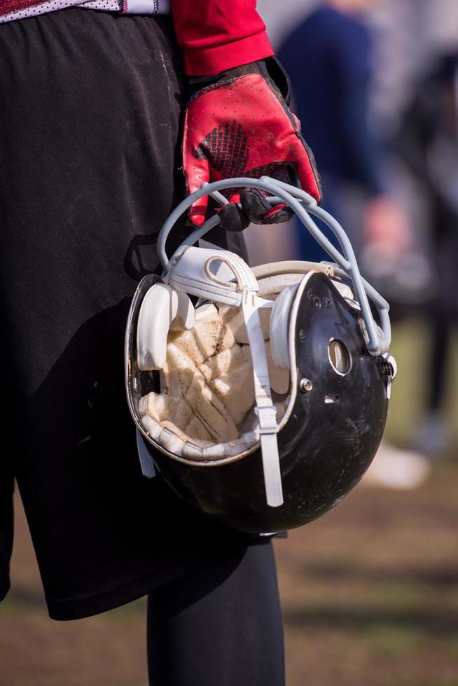 jogador de futebol americano segurando capacete foto