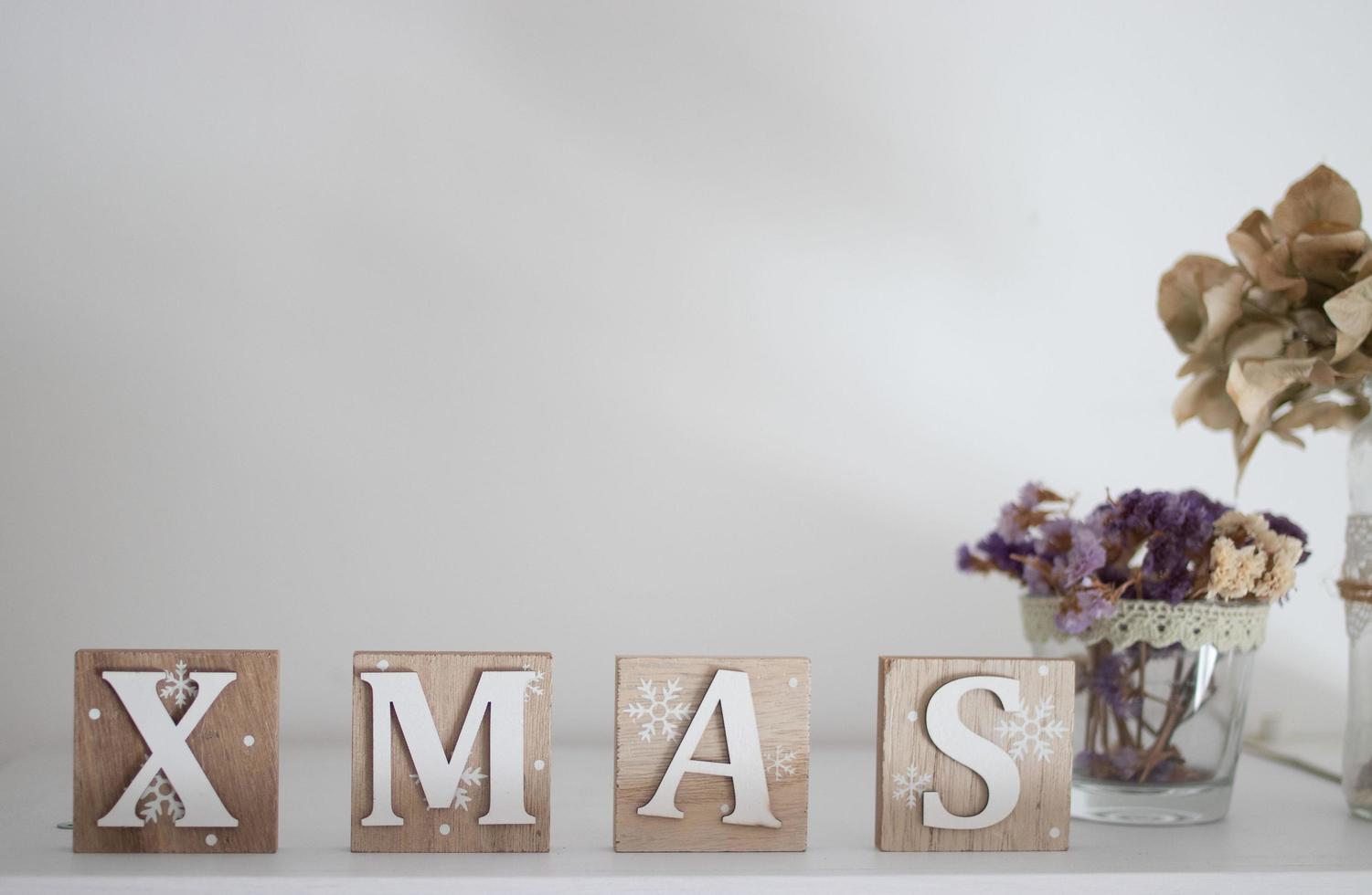 decoração de mesa de madeira com letras de natal em marrom e branco foto