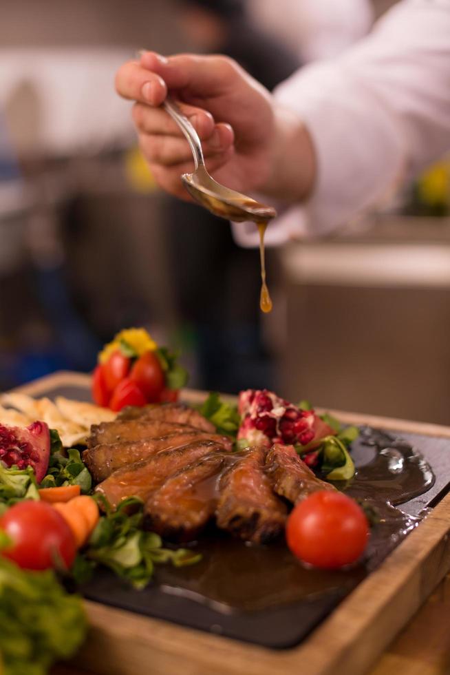 chef terminando o prato de carne de bife foto