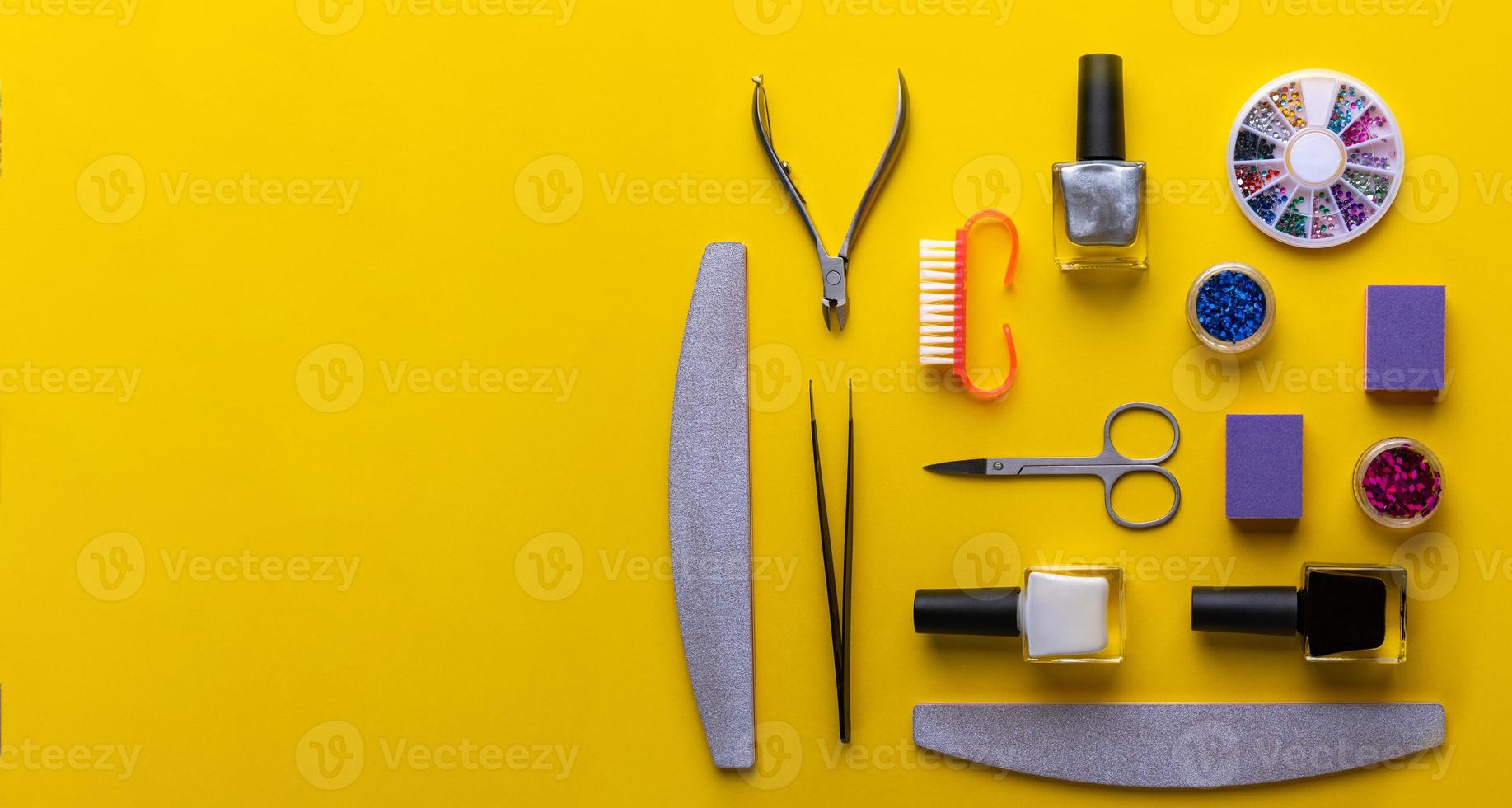 ferramentas e acessórios de manicure e pedicure na vista superior de fundo amarelo. foto