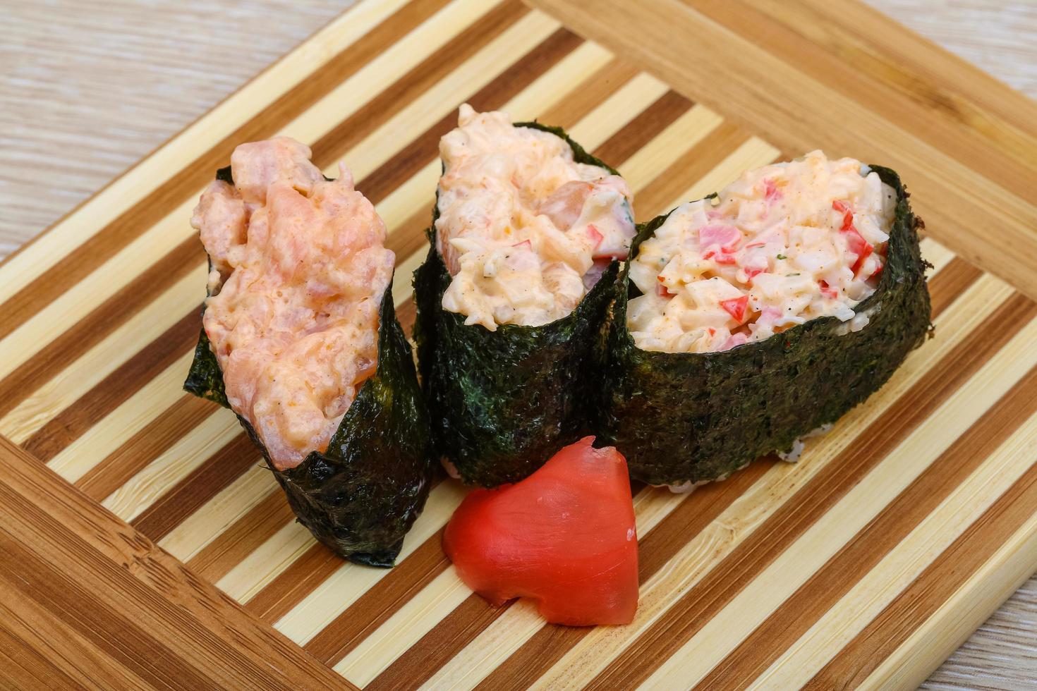 sushi gunkan na placa de madeira e fundo de madeira foto