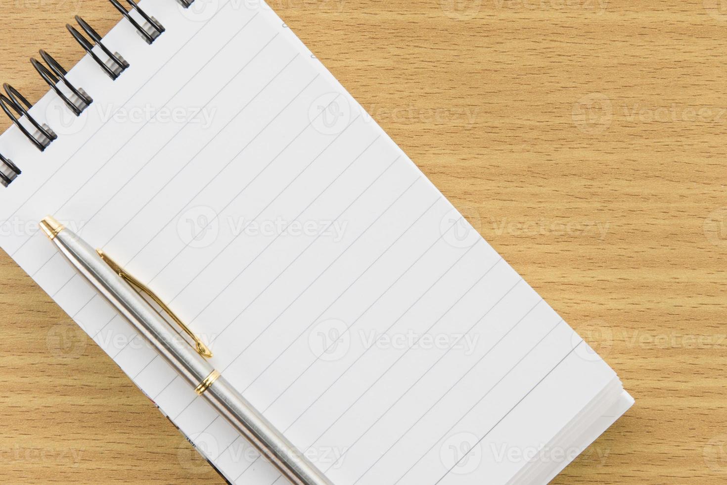 caneta e bloco de notas com página em branco foto