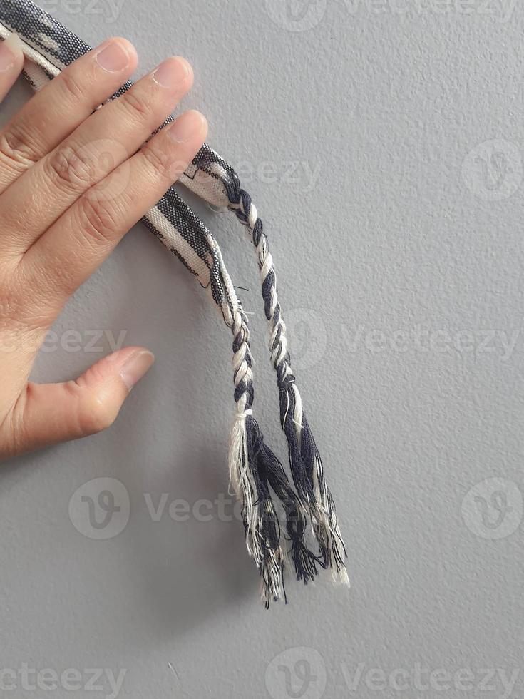 uma mão está segurando uma pulseira de pano. foto