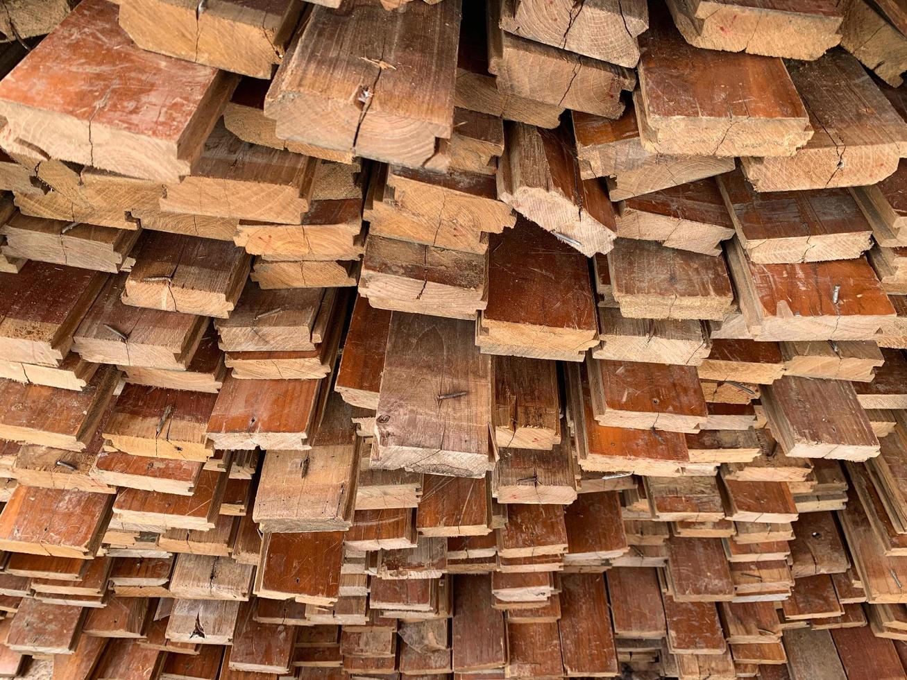 fundo abstrato de madeira empilhado irregularmente, tábuas de madeira velhas se preparando para a construção da casa, padrão na borda de vários pedaços de madeira. foto