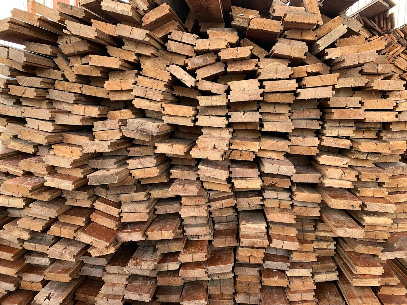 fundo abstrato de madeira empilhado irregularmente, tábuas de madeira velhas se preparando para a construção da casa, padrão na borda de vários pedaços de madeira. foto